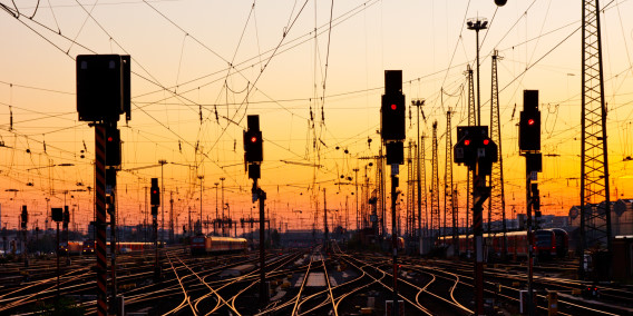 Bahngleise mit Signalanlagen im Sonnenuntergang – Stahlprodukte für Bahnprojekte von A+R Profilstahl